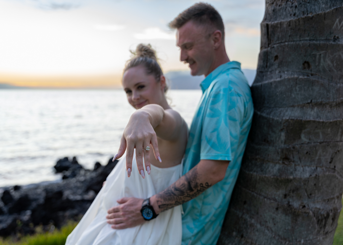 Sunset engaged couple show ring palm tree